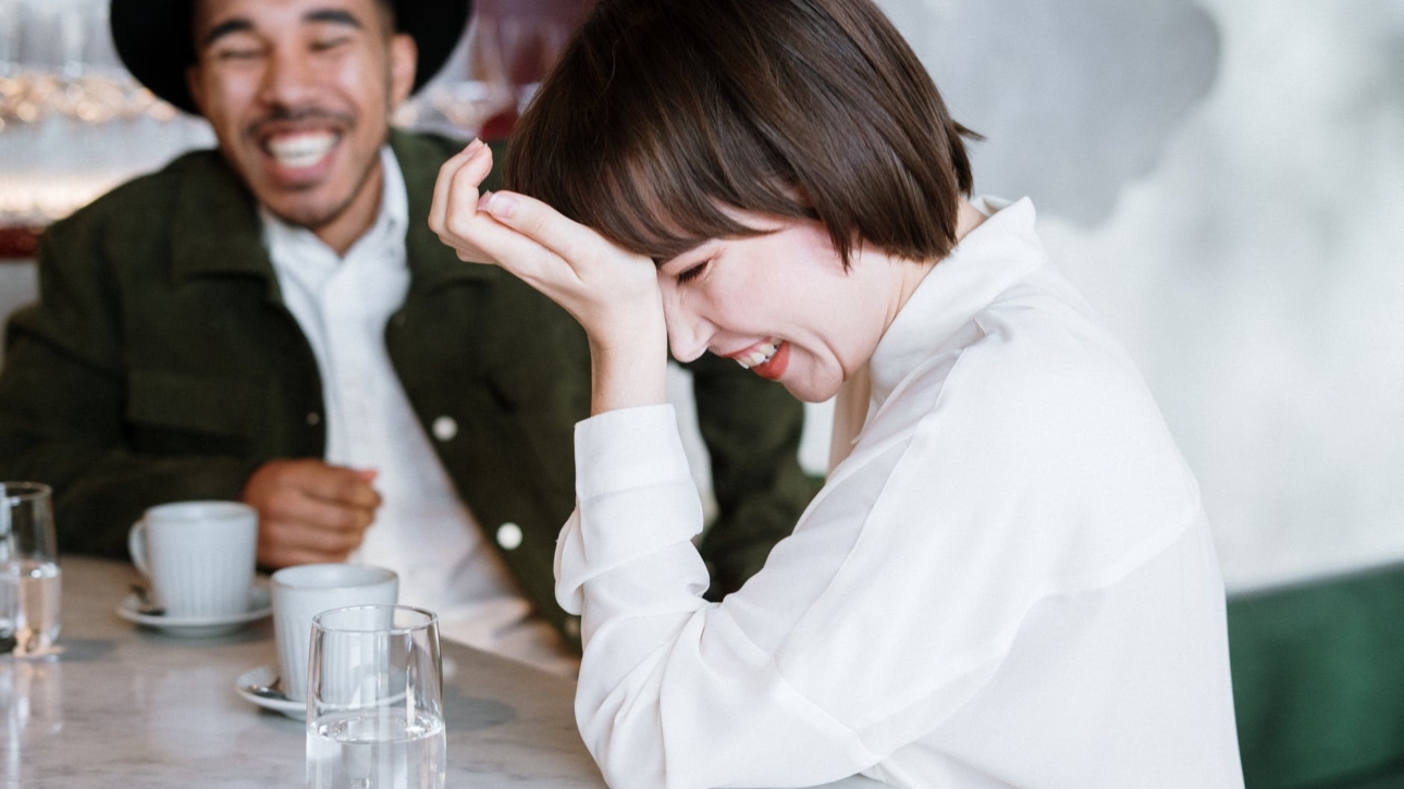 woman in white dress shirt holding clear drinking glass