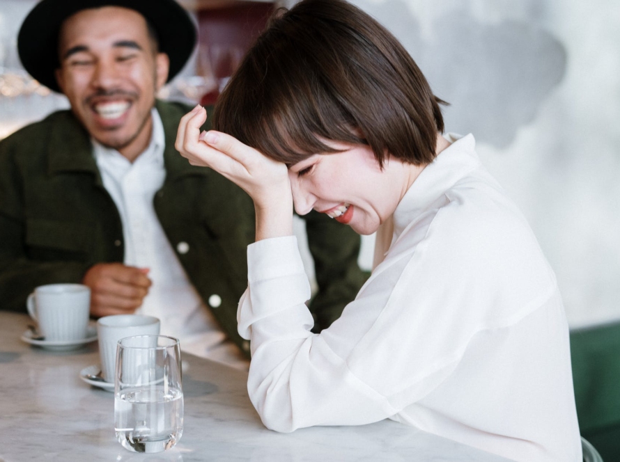 woman in white dress shirt holding clear drinking glass