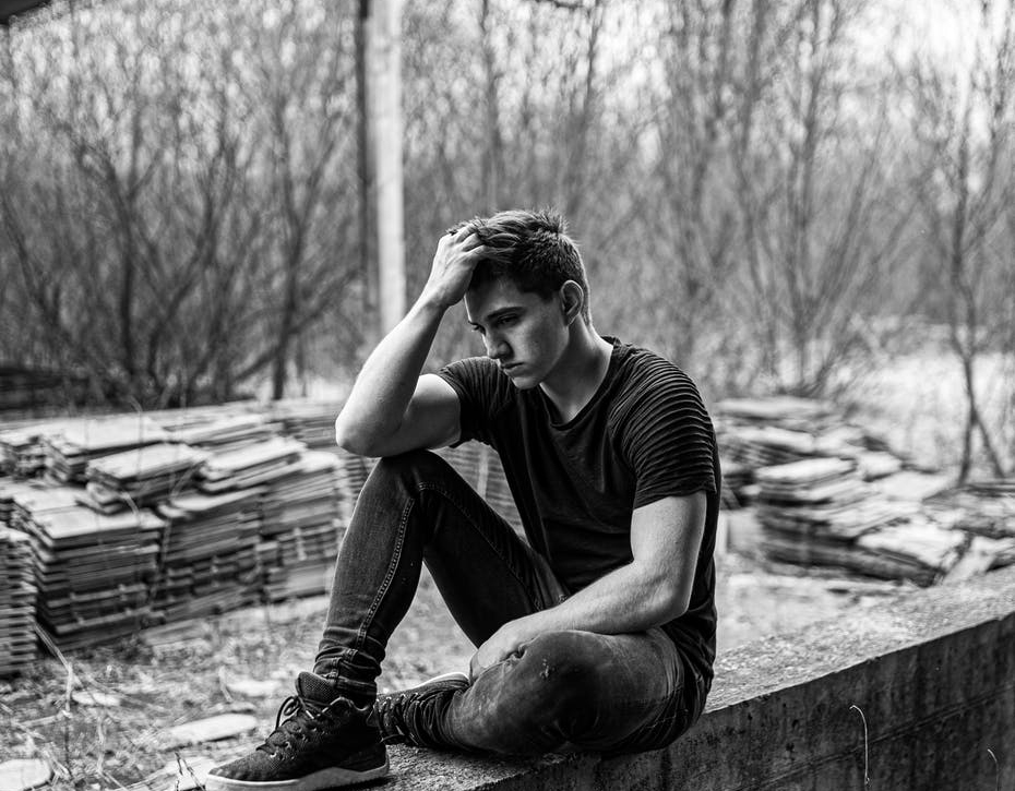 man sitting on concrete bench