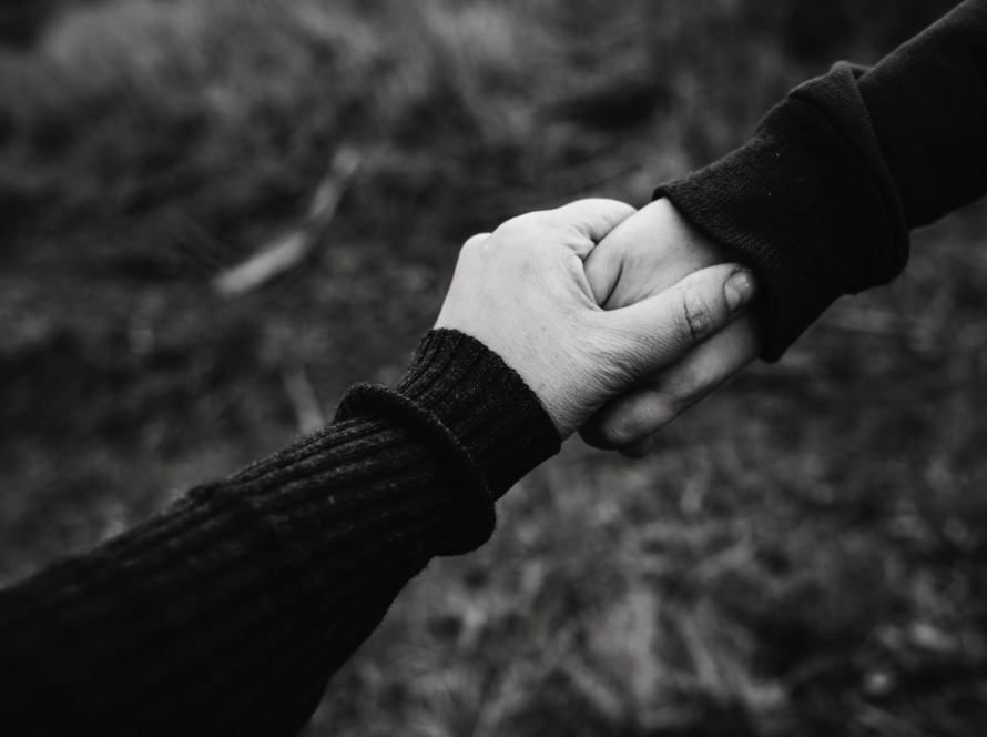 black and white photo of holding hands