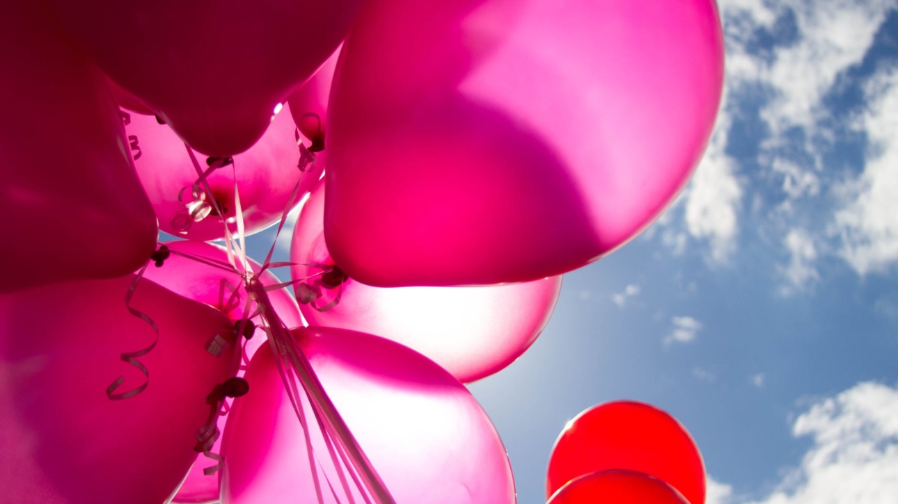 pink and red balloons during daytime