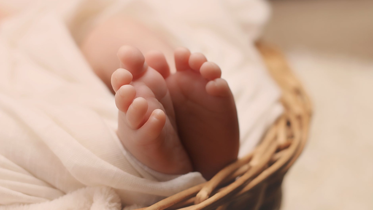baby s feet on brown wicker basket