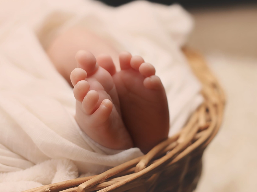baby s feet on brown wicker basket